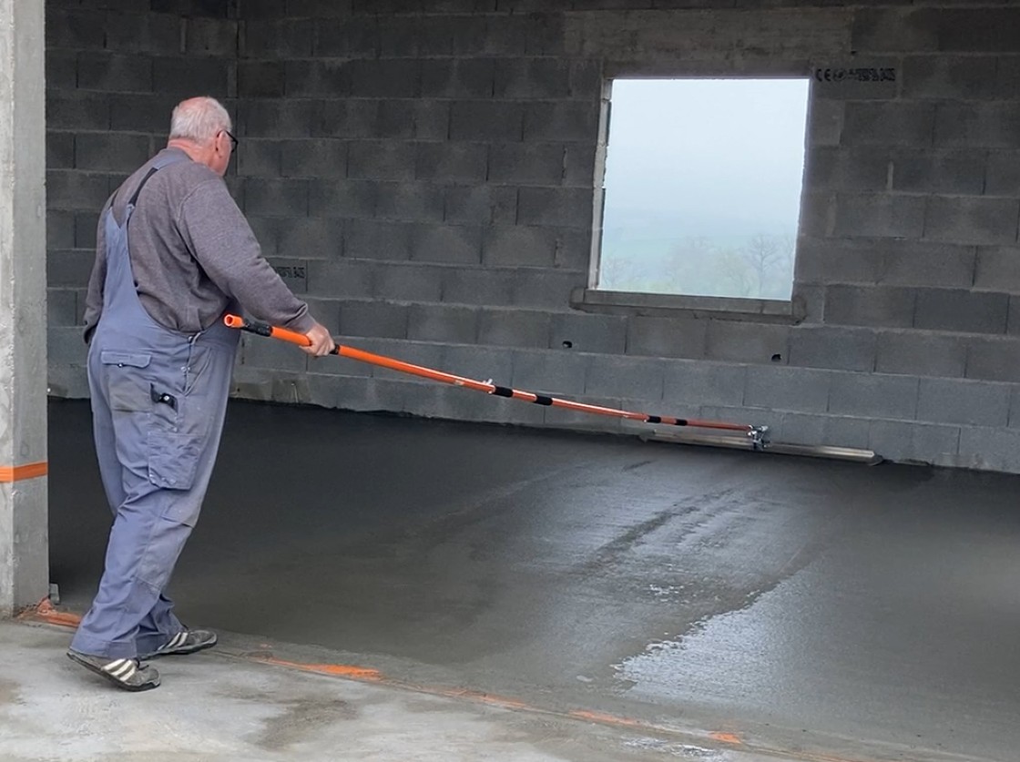Meșter care folosește netezitorul profesional de plăci de beton cu braț telescopic de la Mondelin